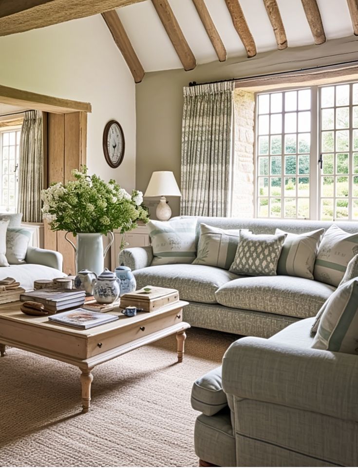 a living room filled with furniture and a clock on the wall above it's windows