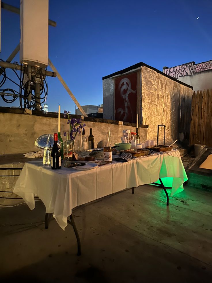 a table that has some bottles and glasses on it with lights in front of it