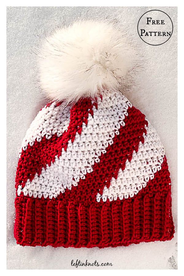 a red and white knitted hat with pom - pom