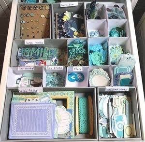 a drawer filled with lots of different types of crafting supplies and paper goods on top of it