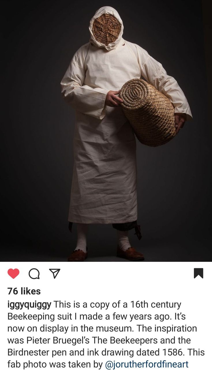 an old man wearing a white coat and holding a basket in one hand while standing against a black background