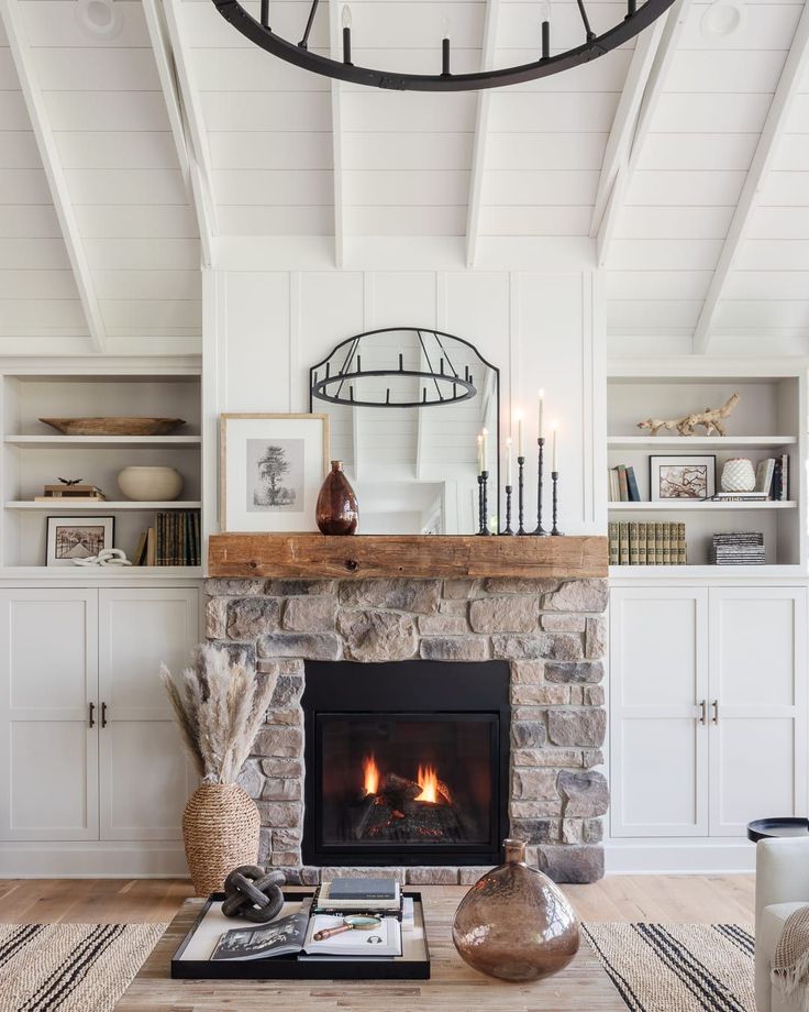 a living room filled with furniture and a fire place in front of a stone fireplace