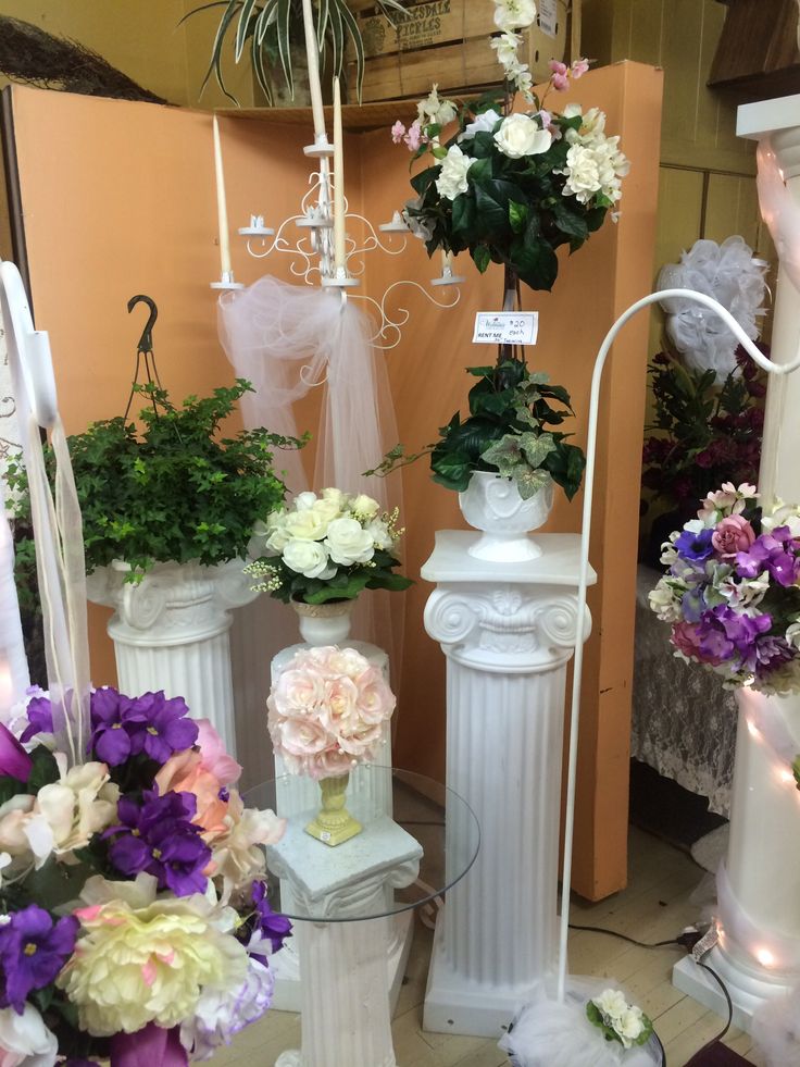 several white vases with flowers in them on display