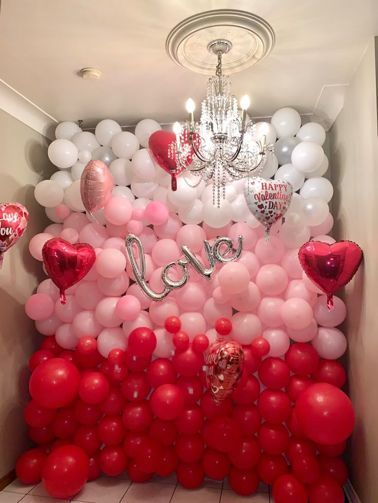 a room filled with lots of red and white balloons that spell out the word love