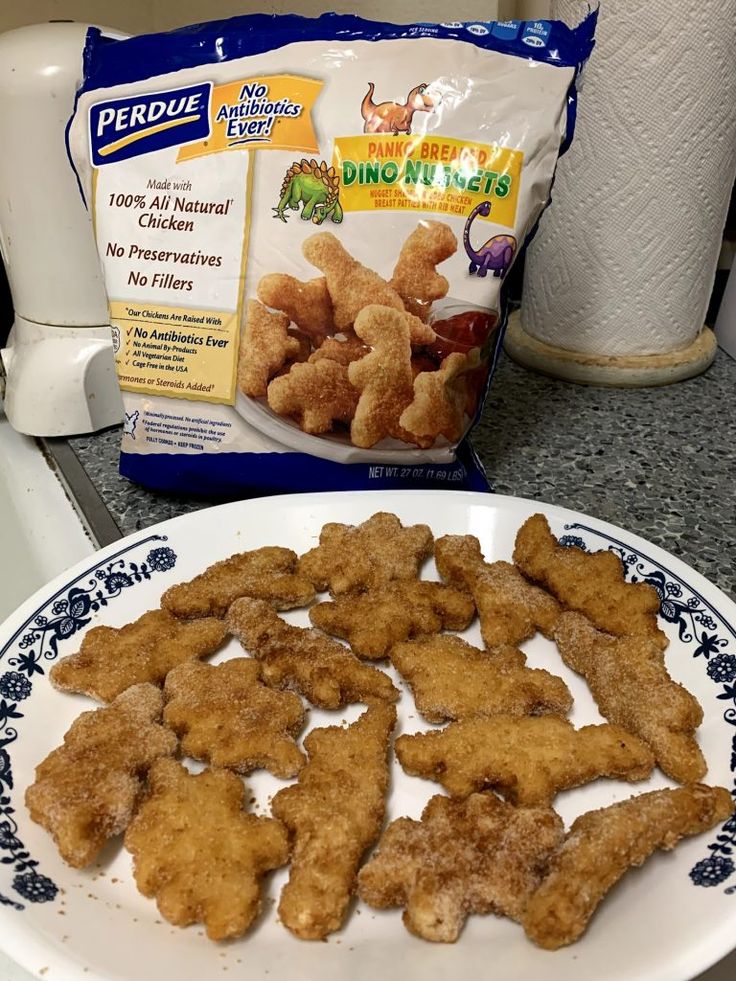 chicken nuggets on a plate next to a bag of ducklings