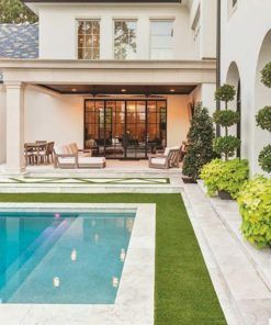 an outdoor swimming pool in front of a house