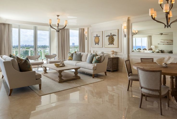 a living room filled with furniture next to a large window covered in curtains and drapes