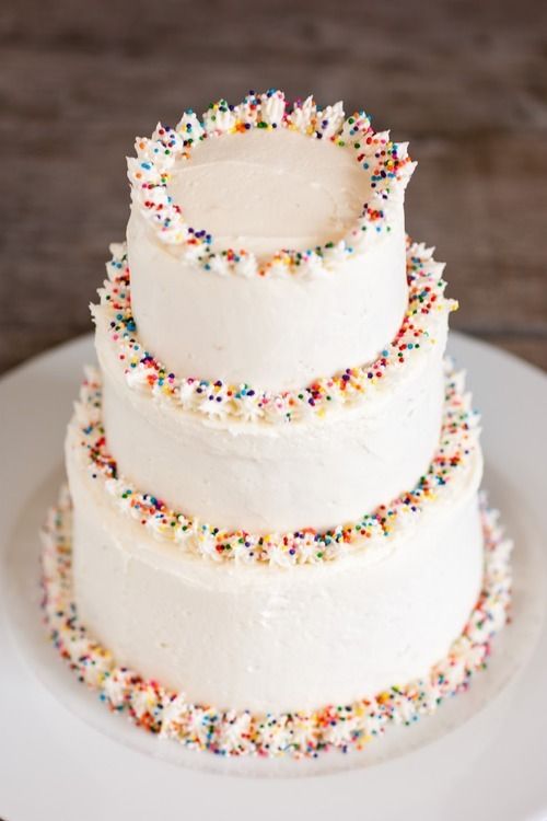 a three tiered cake with sprinkles on it