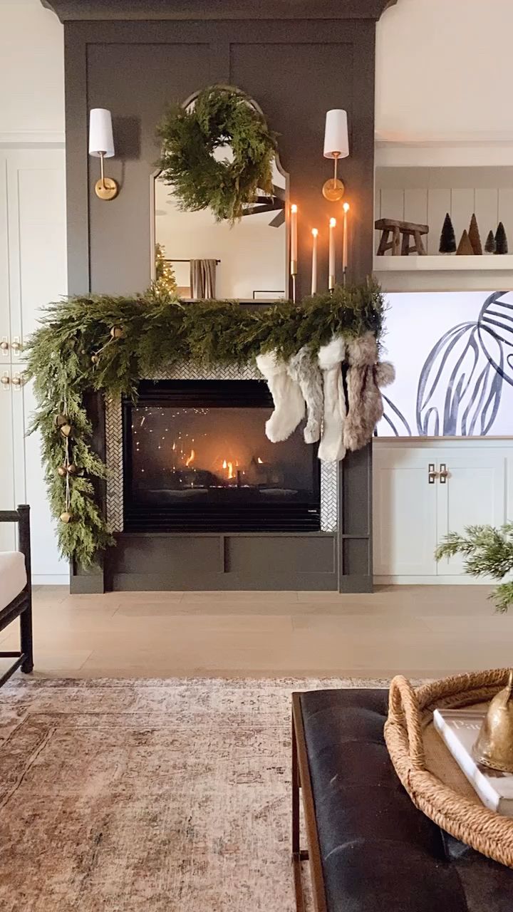 a living room filled with furniture and a fire place covered in wreaths on the mantle