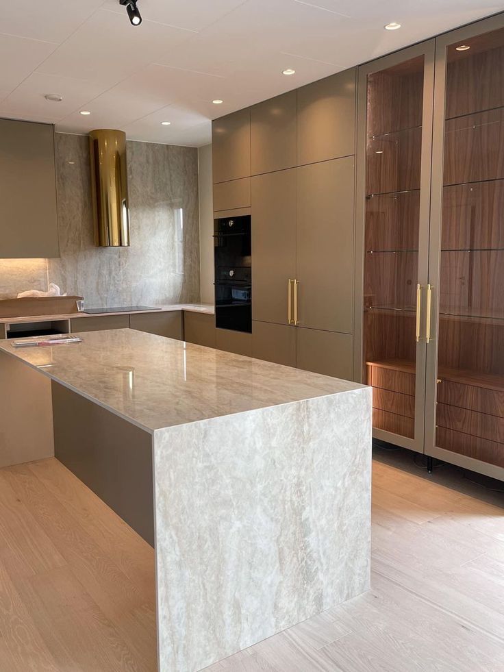 an empty kitchen with marble counter tops and wooden cabinets in the back drop off area