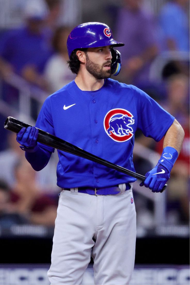 a baseball player holding a bat on top of a field in front of a crowd