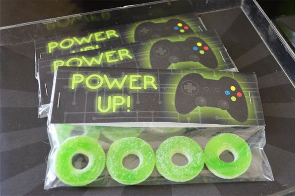 four neon green donuts in packaging with the words power up written on them and three video game controllers