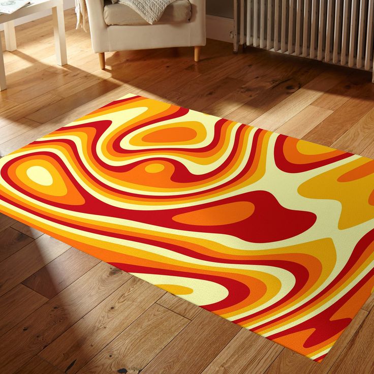 an orange, yellow and red area rug on the floor in front of a white chair