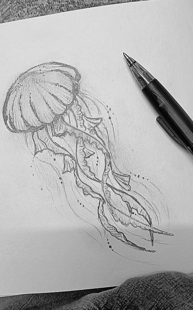 a drawing of a jellyfish on paper next to a pen and ink rollers