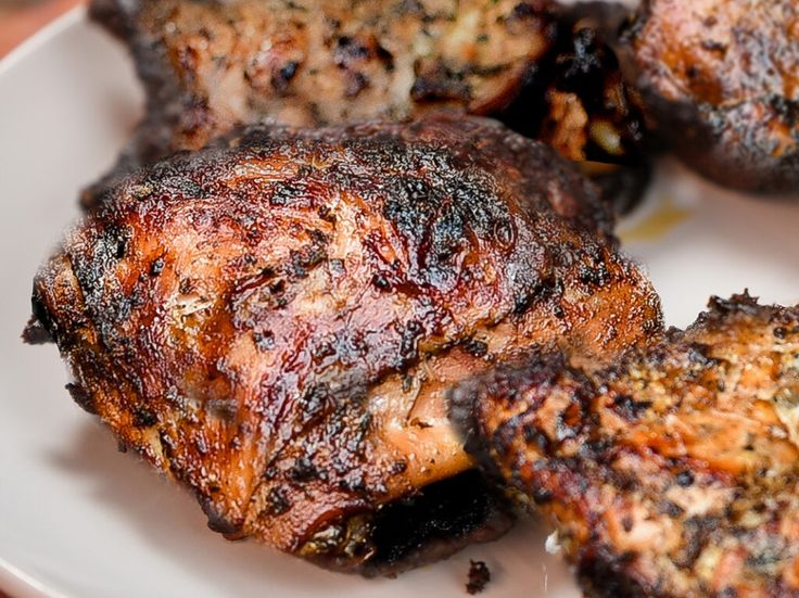 grilled meat on a white plate sitting on a table