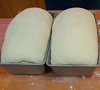 two loafs of bread sitting on top of a wooden table