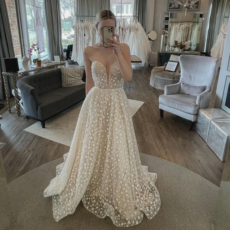 a woman is taking a selfie in her wedding dress at the bridal shop