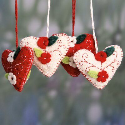 three heart shaped ornaments hanging from strings