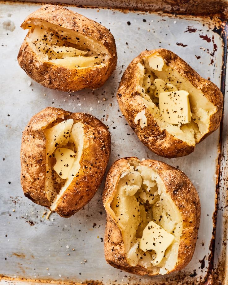 four pieces of bread that have been baked with cheese and herbs in them on a baking sheet