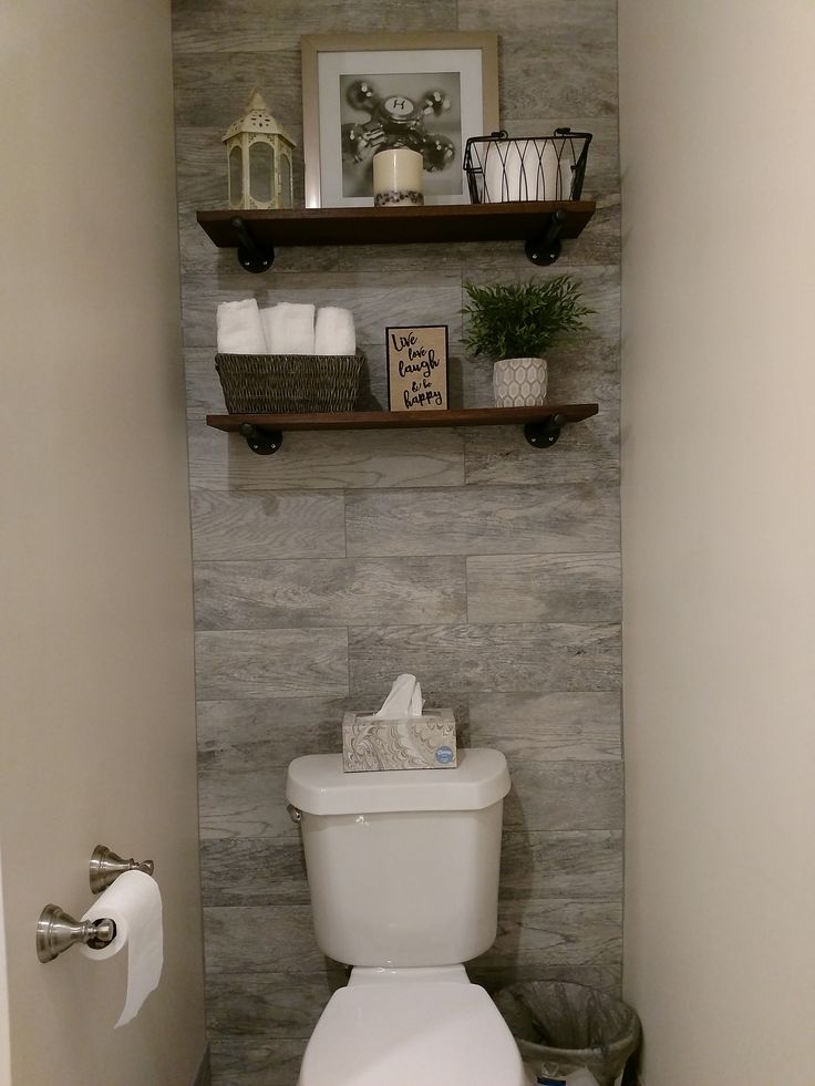 a white toilet sitting in a bathroom next to a shelf filled with towels and other items