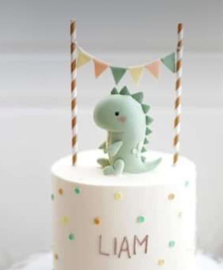 a cake with a dinosaur topper on it's icing and the words i am