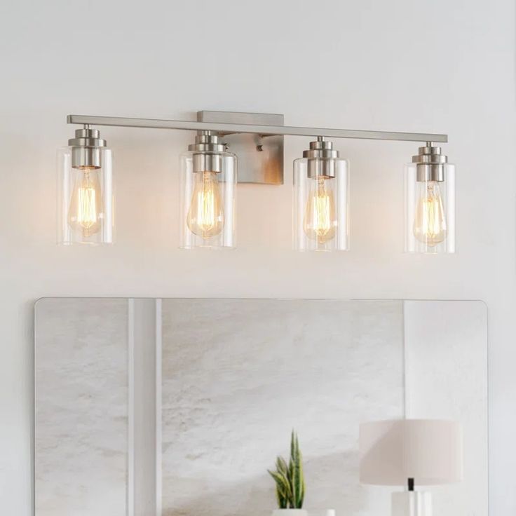 a bathroom vanity light with three bulbs on the side and a mirror in front of it