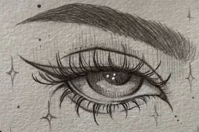 a drawing of an eye with long lashes and stars in the background, drawn on paper