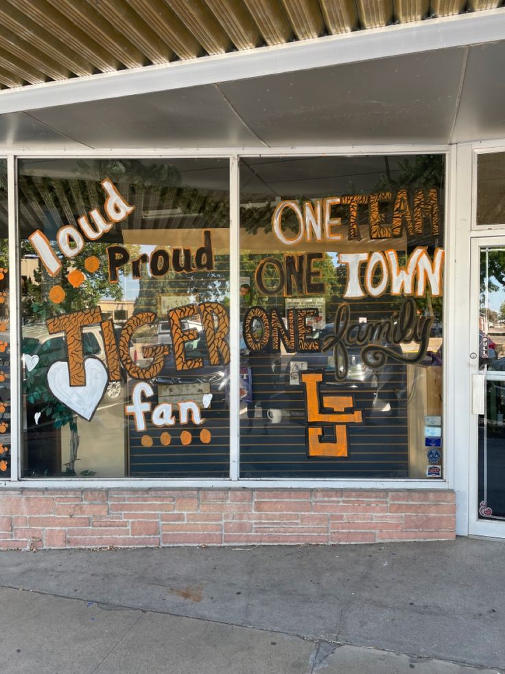 the front window of a store that has been decorated with letters and other things on it