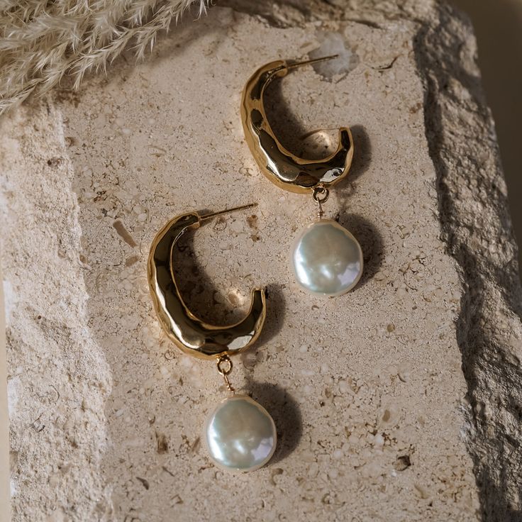 Look stunning in any occasion with the Maxine Pearl Hoops! These elegant earrings are crafted with freshwater flat pearls to give you a glamorous and timeless look. Show your true beauty with these gorgeous and exquisite hoops! EARRINGS FEATURE Freshwater flat pearls hand wire wrapped in 14k gold filled wire 16k gold plated brass hammered hoop (19 x 30mm) .925 sterling silver post