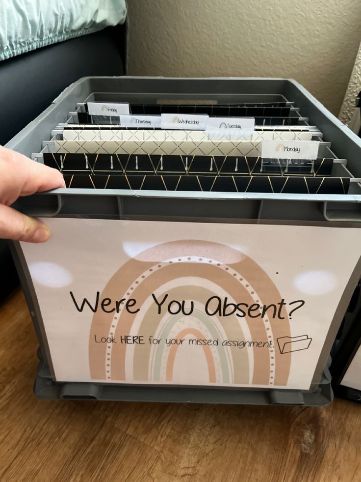 a person is holding a file box with several files in it and there are other folders on the table