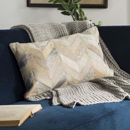 a blue couch with a book on it and a potted plant in the corner