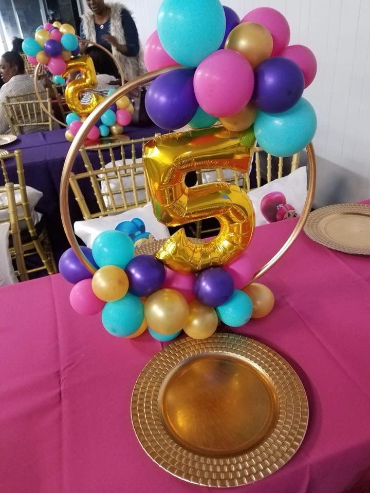 the table is set up with balloons and gold numbers