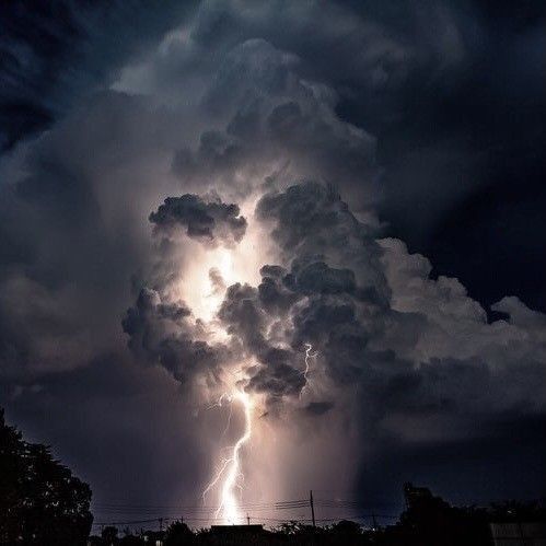 a large cloud filled with lots of dark clouds and lightning striking in the sky above