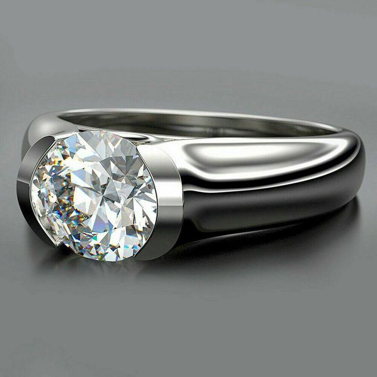 a ring with a diamond in it on a gray surface, showing the center stone