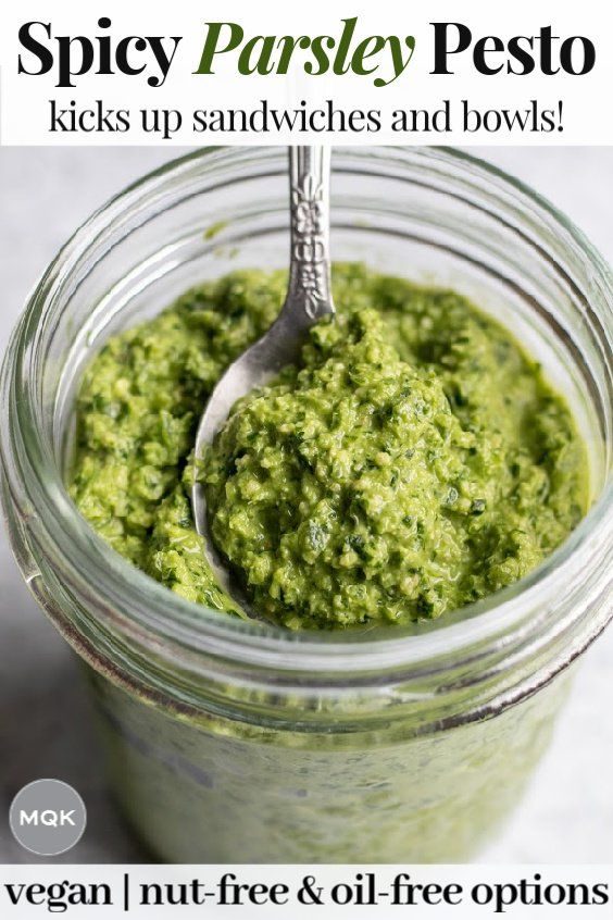 a jar filled with pesto next to a spoon