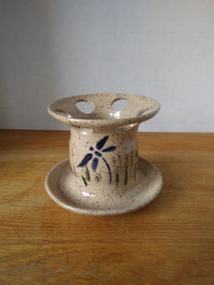 a small ceramic vase sitting on top of a wooden table