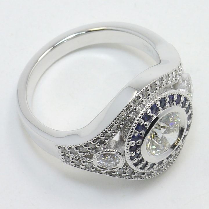 a diamond and blue sapphire ring on a white background