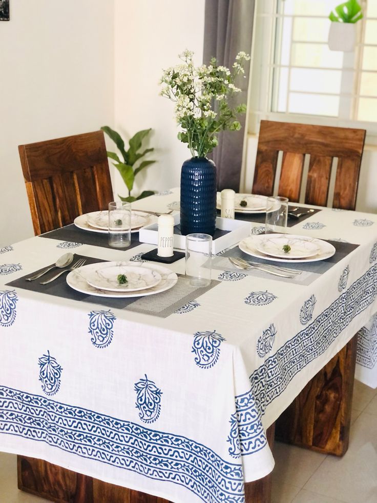 the table is set with plates and place settings for two people to enjoy dinner together