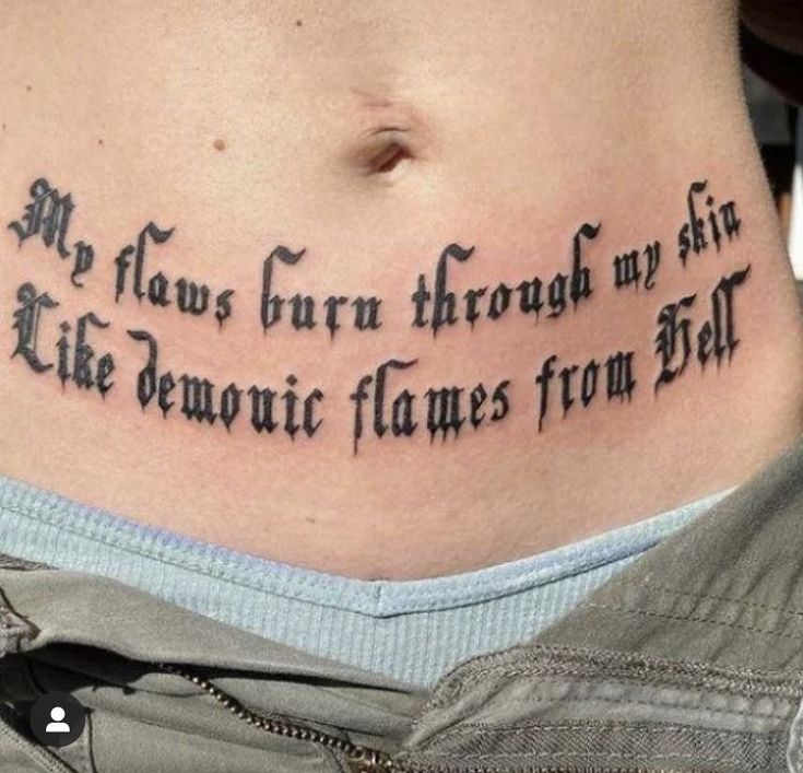 a woman with a tattoo on her stomach that reads, my flowers grow through my skin like demonic flames from hell