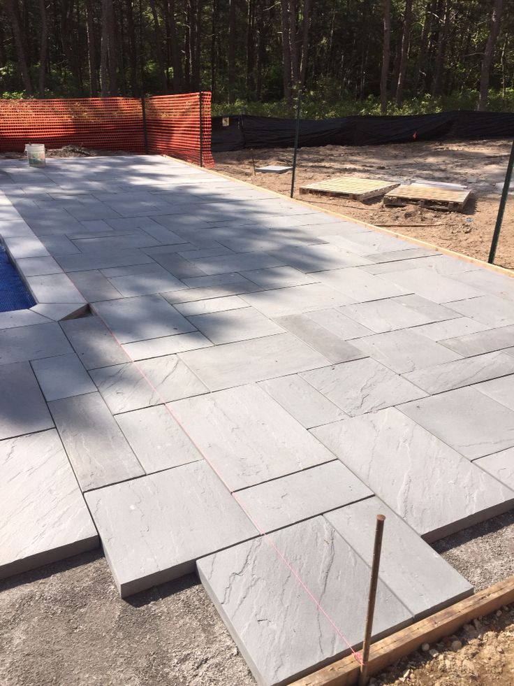 an outdoor patio being built in the middle of a wooded area with concrete blocks laid around it