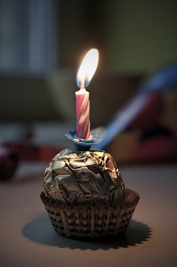 a cupcake with a lit candle on it