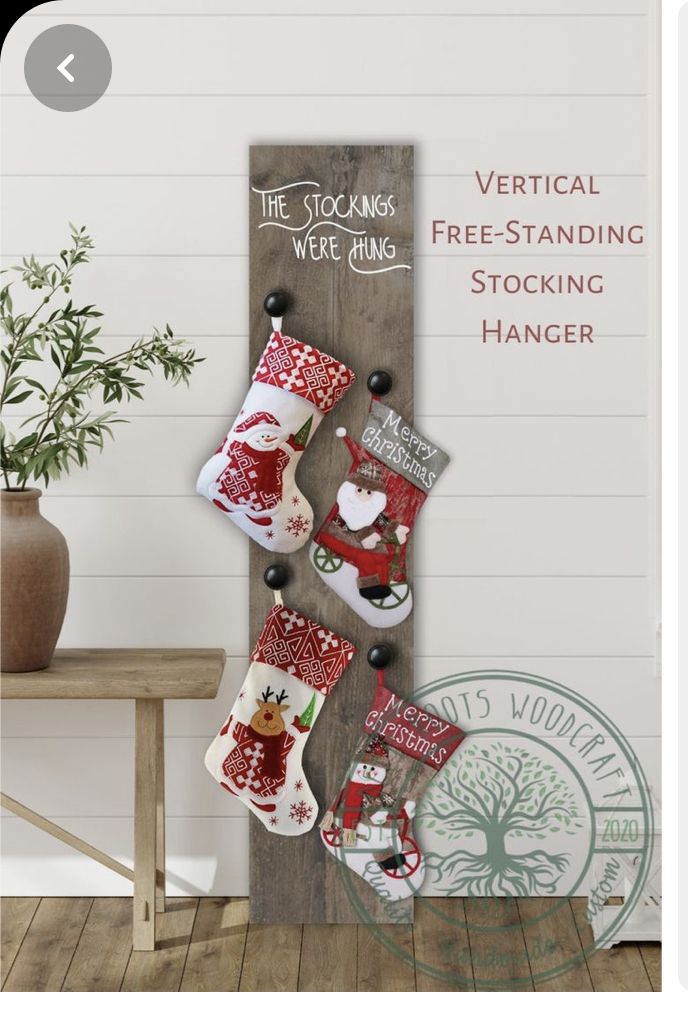 a christmas stocking hanging on a wooden sign with santa claus and reindeer stockings attached to it