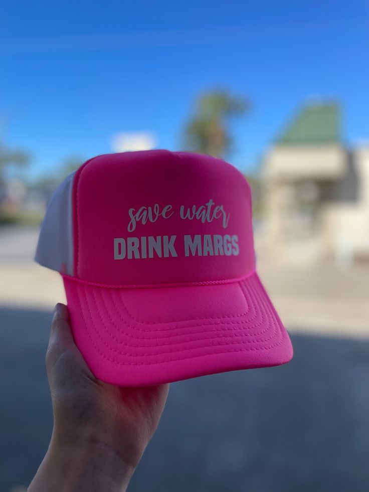 Stay cool and hydrated this summer with our Save Water Drink Margs Puff Hat in Neon Pink. Perfect for a day at the beach, this playful puff hat adds a touch of fun to your outfit while reminding you to stay hydrated. Cheers to summer! Summer Lightweight Snapback Trucker Hat, Pink Fun Sun Hat For Beach Season, Fun Pink Sun Hat For Vacation, Pink Summer Hat For Poolside, Trendy Trucker Hat For Summer Outdoor Activities, Lightweight Snapback Trucker Hat For Summer, Playful Pink Sun Hat For Beach Season, Lightweight Summer Trucker Cap, Lightweight Summer Trucker Hat