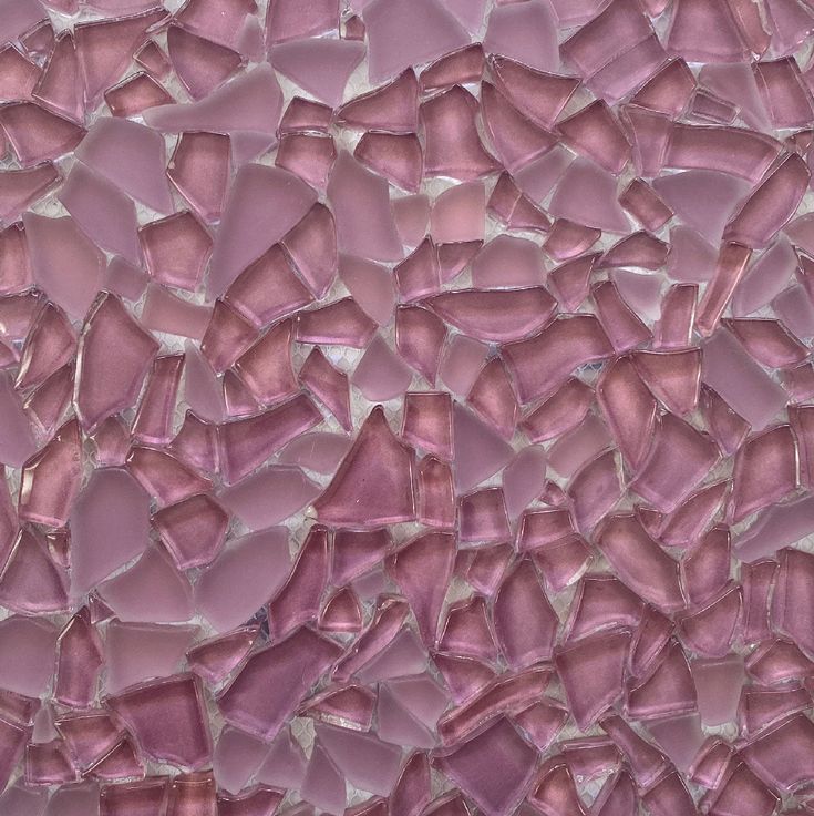 a close up view of a pink glass mosaic tile wall that looks like it has been broken in half