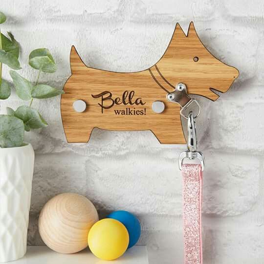 a wooden key holder with a dog on it and a ball in front of it