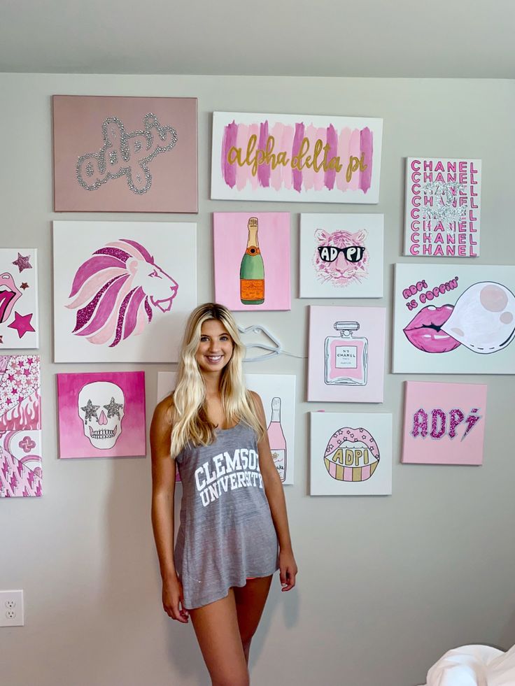 a woman standing next to a wall covered in pictures