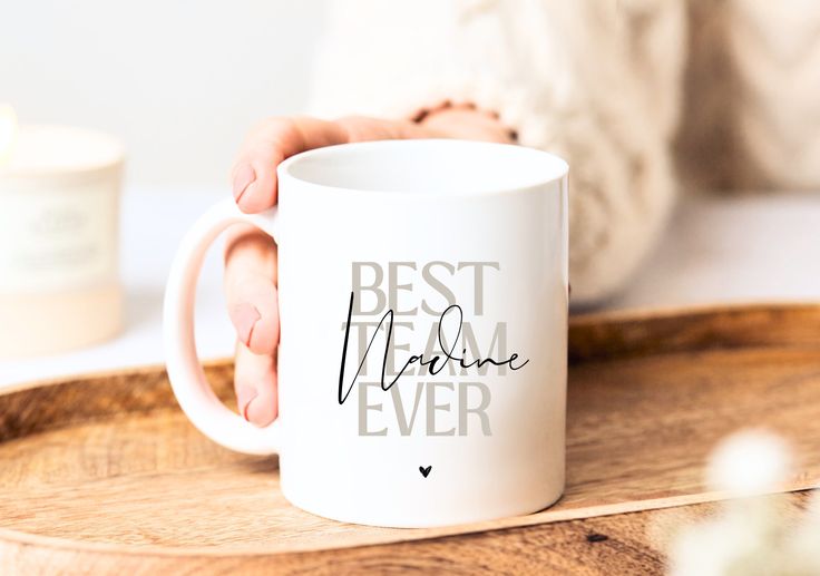 a person holding a white coffee mug with the words best mom ever on it in black