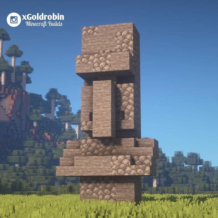 a tall tower made out of rocks in the middle of a field with trees and bushes