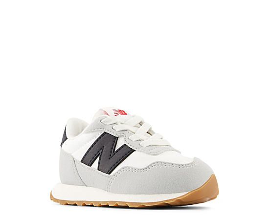 New Balance 237 Toddler Infant Boys' Sneaker - White Introducing the running heritage of the '70s to a new generation, the 237 infant boys' Sneaker , inspired by the New Balance 327, combines simplistic style with modern performance. With a suede & nylon upper featuring an oversized N logo for vintage appeal, this lace-up Shoe also has an exposed foam tongue for extra comfort. The EVA midsole cushions every step, while the herringbone outsole and mudguard protect and stabilize. Baby Boy Sneakers, New Balance 327, Rack Room Shoes, Sneakers White, Lace Up Shoes, Herringbone, Toddler Boys, New Black, New Balance