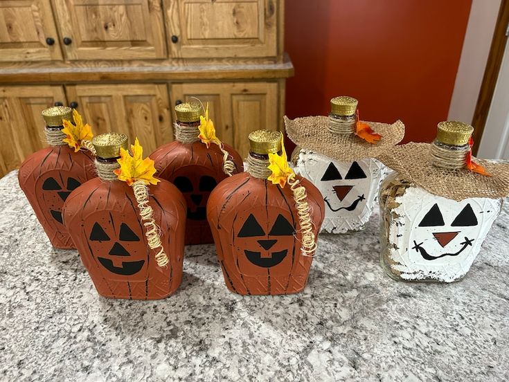 three pumpkin shaped wine bottles sitting on top of a counter